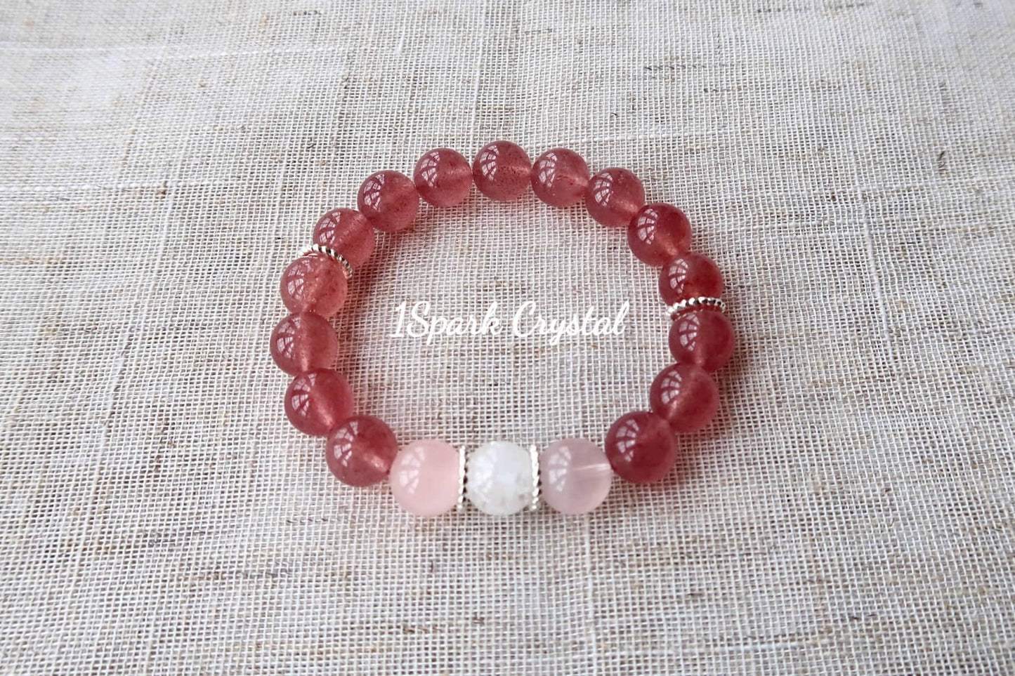 Love Manifestation crystal bracelet with silver accents, beautifully reflecting light to showcase the brilliance of strawberry quartz, rose quartz, and clear quartz crystals