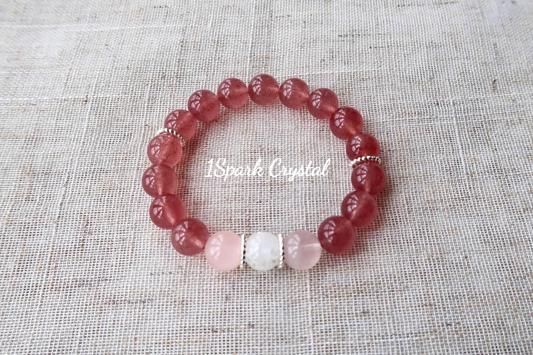 Love Manifestation crystal bracelet with silver accents, beautifully reflecting light to showcase the brilliance of strawberry quartz, rose quartz, and clear quartz crystals