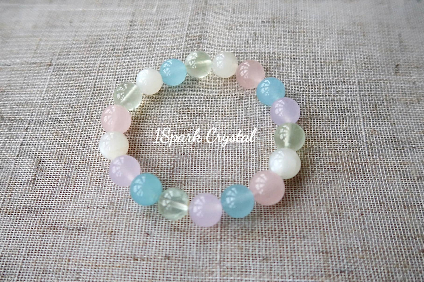 Lucky Charm handmade crystal bracelet with morganite, prehnite, rose quartz, and white moonstone, highlighting the harmonious arrangement of the crystals in a full-view image