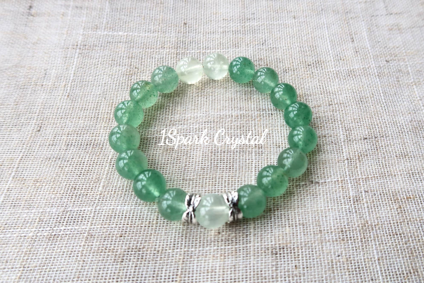 Mindful Journey crystal bracelet featuring green strawberry quartz and prehnite, reflecting light to emphasize the bracelet’s tranquil energy and gentle design