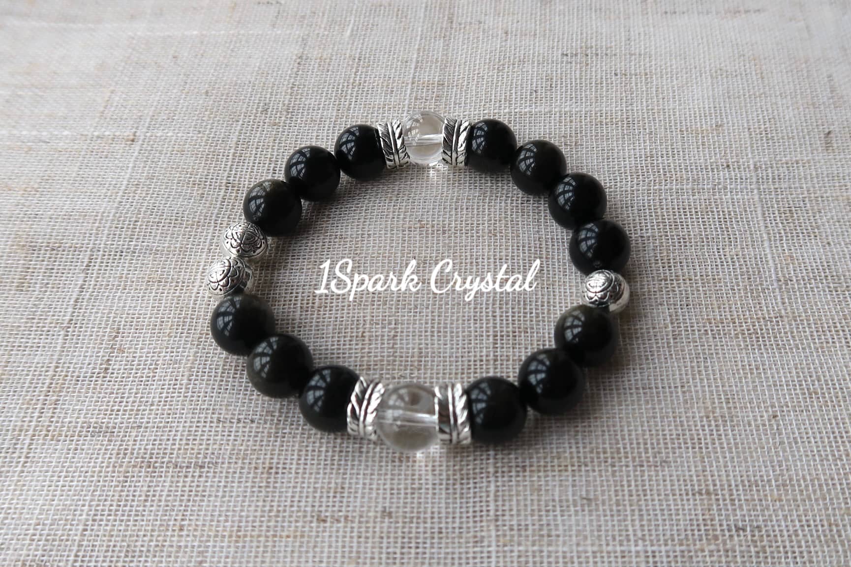 Mystic Protection handmade crystal bracelet featuring black obsidian, clear quartz, and silver accents, displayed in a full view showcasing its bold and protective design